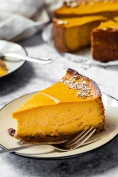 a slice of pumpkin cheesecake on a plate with a fork next to the pie