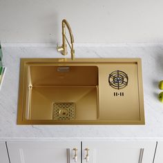 a kitchen sink with a gold faucet and drainer