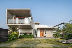 a modern house in the middle of a lush green yard with stairs leading up to it