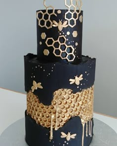 a three tiered cake decorated with honeycombs and bees