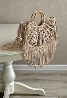 a purse sitting on top of a table next to a white chair with a wooden handle