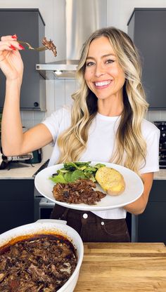 a woman holding a plate of food in her hands