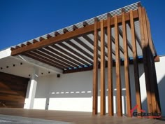 a wooden structure sitting on top of a hard wood floor next to a white building