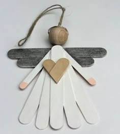 an angel ornament made from popsicle sticks with a wooden heart on it