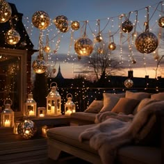 an outdoor deck with lights and lanterns hanging from it's ceiling above the couch