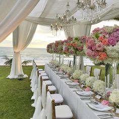 a long table set up with flowers and place settings