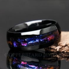 "This black galaxy ring is gorgeous! It features a mesmerizing design reminiscent of swirling gas and dust clouds found in galaxies, this ring boasts a stunning array of colors that evoke the celestial splendor of the night sky. Deep blues, purples, pinks, and oranges come together in a breathtakingly beautiful pattern, creating a sense of cosmic movement and dynamism that is sure to captivate the imagination. Beautiful color shifting effect! || Features || - Solid and strong tungsten band - Dom Space-themed Black Jewelry Gift, Galaxy Rings, Promise Ring Men, Cosmic Being, Blue Sandstone Ring, Fantasy Jewelry Magic, Stars Beautiful, Sandstone Ring, Cosmic Ring