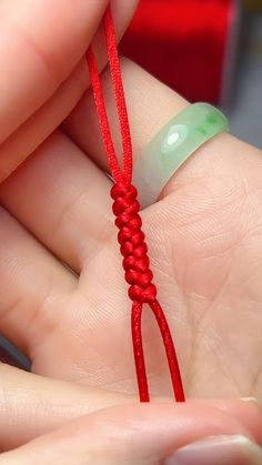 a person is holding a red string in their hand