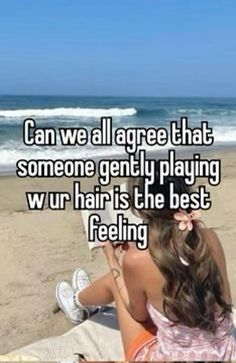 a woman sitting on top of a beach next to the ocean with text saying can we all agree that someone gently playing wur hair is the best feeling