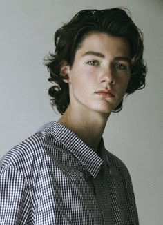 a young man with curly hair wearing a shirt