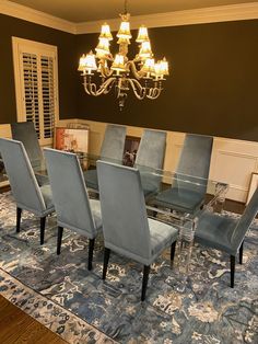 a dining room table with blue chairs and a chandelier