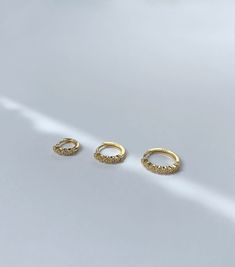 "- Materials * Gold plated 18 carat over 925 sterling silver * Available also in 925 sterling silver * Brilliant round AAA cubic zirconia Stones * Nickel free hypoallergenic for sensitive skin * Lightweight * Sold in single or in a pair - Measurements * Inner Diameter: 6mm, 8mm, 10mm * Outer Diameter: 9mm, 11mm, 13mm All jewelry are ready-for-gift, which come in beautiful packaging. [ Designed and Made in AnotherEast at New York Studio] ♥︎FOLLOW US HERE: https://www.pinterest.com/anothereast2019 Gold Cubic Zirconia Huggie Earrings For Everyday, Minimalist Gold Huggie Earrings With Cubic Zirconia, Everyday Gold Cubic Zirconia Huggie Earrings, Gold Minimalist Cubic Zirconia Huggie Earrings, Gold Plated Huggie Single Earring, Gold Plated Single Huggie Earring, Gold Plated Huggie Single Earring Piercing, Gold-colored Sterling Silver Small Hoop Piercings, 14k Gold Huggie Earrings With Halo