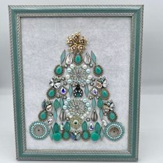 Vintage jewelry tree in light green melon color made with a vintage gold-tone rose and faux pearl brooch, vintage necklace pieces with teardrop crystals, marquis-shaped bracelet pieces, small vintage ladybug brooch, light green plastic teardrop beads, round light jade green glass beads, faux pearls, gold tone filler pieces, iridescent rhinestones, petite beaded earrings. Wood frame with easel back and wall-hanging hardware attached. Vintage Green Jewelry With Unique Variations, Victorian Green Jewelry For Party, Christmas Wedding Beaded Jewelry, Unique Collectible Jeweled Jewelry, Green Cabochon Jewelry For Party, Unique Jeweled Jewelry For Anniversary, Unique Pear-shaped Gold Jewelry, Artistic Green Jewelry For Party, Unique Jeweled Jewelry As Gift