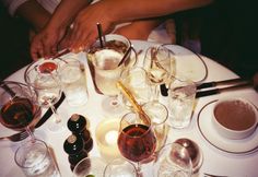 a table topped with lots of wine glasses and plates filled with different types of drinks