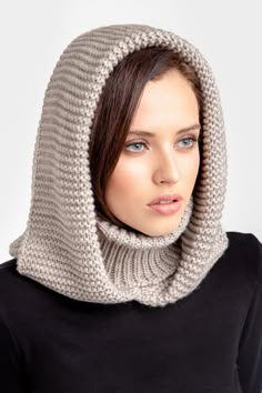 a woman wearing a gray knitted cowl with a hood on her head and neck