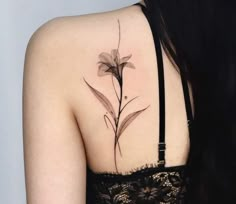 the back of a woman's shoulder with a flower tattoo on her upper arm