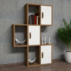 a book shelf that has some books on it and two vases next to it