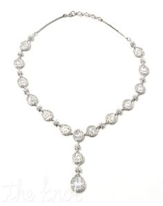 a necklace with white stones on it and a diamond droplet hanging from the side