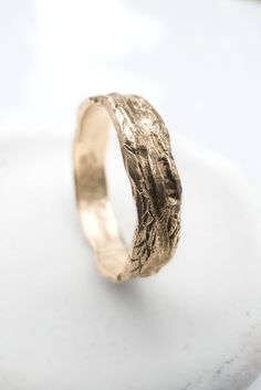 a close up of a gold ring on a white surface