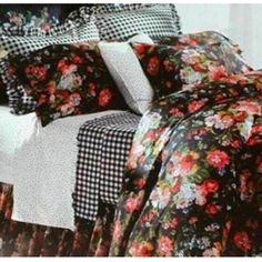 a bed covered in black and white floral comforter sets with checkered pillow cases