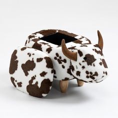 a toy cow with brown spots on it's face