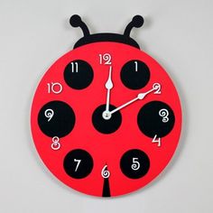 a red clock with black numbers and a ladybug design on the front side