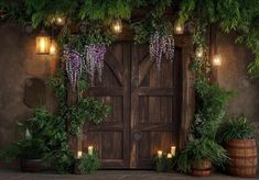 a wooden door surrounded by potted plants and lit candles in front of an entrance