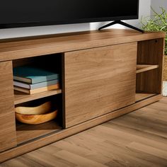 a flat screen tv sitting on top of a wooden cabinet