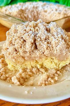 a piece of cake on a plate with some powdered sugar in the middle and another pie behind it