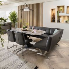 a dining room table with chairs and a bench in front of a wall mounted planter