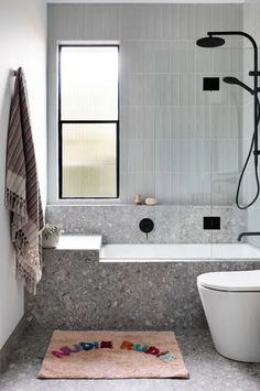 a bathroom with a bathtub, toilet and shower head in the middle of it