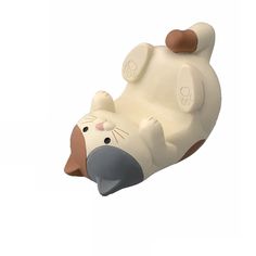 a white and brown toy animal laying on its back with it's mouth open