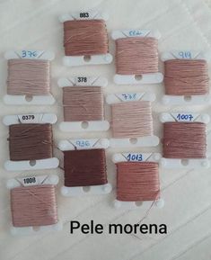 several spools of thread are shown on a white surface with different colors and sizes