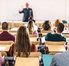 a man standing in front of a class room full of students