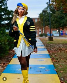 a woman is walking down the sidewalk wearing yellow boots and a black jacket with stripes on it