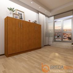 an empty living room with wood floors and white walls, looking out onto the city