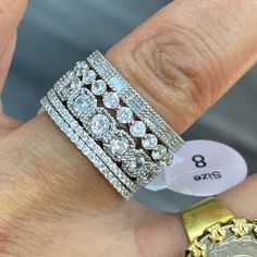 a close up of a person's hand with three rings on it