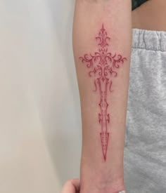 a woman's arm with a cross tattoo on it