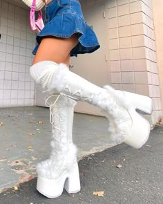 a woman wearing white boots and holding a pink purse