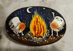 a painted rock with three cartoon characters around a campfire