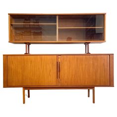 a large wooden cabinet with glass doors on the top and bottom, against a white background