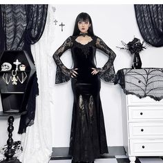 The wannathis Gothic Velvet Mermaid Gown is an elegant, floor-length dress featuring long sleeves, lace detailing, and a high collar. This gown combines the luxurious texture of velvet with intricate lace accents, creating a sophisticated and dramatic gothic look. Fabric composition: 95% Polyester, 5% Spandex (Elastane) Formal Long Sleeve Maxi Dress With Lace Sleeves, Formal Long Sleeve Lace Maxi Dress, Formal Long-sleeve Lace Maxi Dress, Fitted Gown With Sheer Long Sleeves, Fitted Long Gothic Dress, Black Gown With Lace Long Sleeves, Evening Long Sleeve Maxi Dress With Lace Trim, Long Sleeve Maxi Dress With Lace Trim For Evening, Gothic Long Sleeve Dress For Night Out