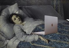 a woman laying in bed with an apple laptop