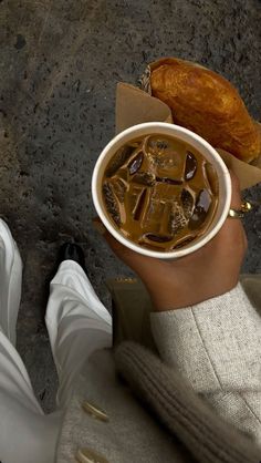 a person holding a cup of iced coffee