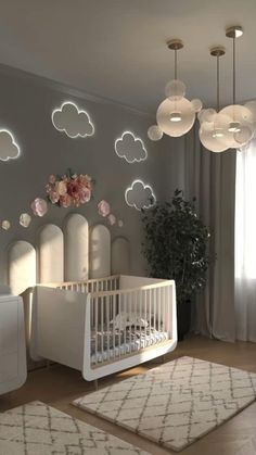 a baby's room decorated in white and pink with clouds on the wall above it