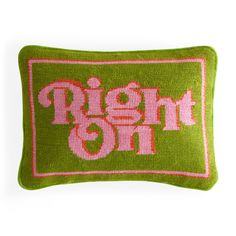 a green pillow with pink lettering on it