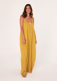 [Color: Mustard] A front facing image of a brunette model wearing a mustard yellow harem maxi dress. This billowy maxi tank top dress features a deep v neckline Chic Rayon Maxi Dress For Beach Cover-up, Chic Summer Maxi V-neck Dress, Solid V-neck Beach Cover-up Dress, Casual V-neck Maxi Dress For Date Night, Chic V-neck Rayon Maxi Dress, V-neck Maxi Sundress For Day Out, Chic Unlined V-neck Maxi Dress, Chic Solid Color Slip Dress For The Beach, Chic Slip Dress For The Beach