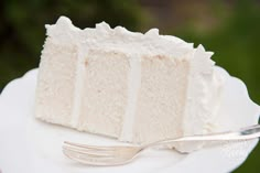 a slice of white cake on a plate with a fork