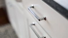 an old fashioned white cabinet with chrome handles