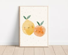 two oranges with faces drawn on them sitting in front of a white wall